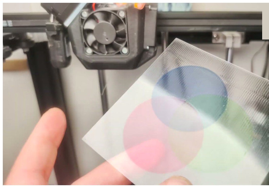 A finished multi-color 3D print held in front of the printer that made it