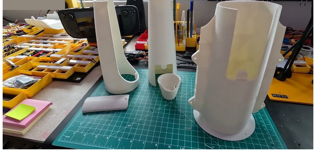 Three printed PETG parts laid out on a cutting mat after dialing in the OrcaSlicer anti-stringing profile